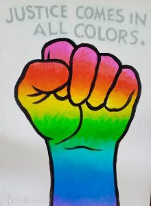 shows a fist that is rainbow colored and it says Justice comes in all colors above the fist